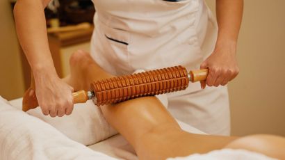Therapist performing Wood Therapy treatment on client’s body to sculpt and contour