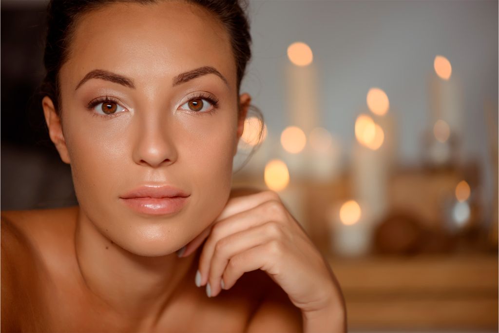 Woman with glowing, radiant, and healthy skin after following a 10 must-have skincare products
