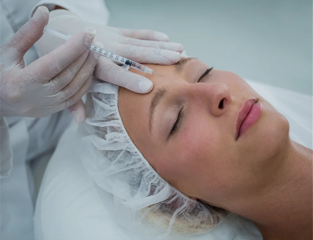 Professional injector applying Botox to the temples and forehead area to reduce wrinkles at Akasha Wellness & Spa.