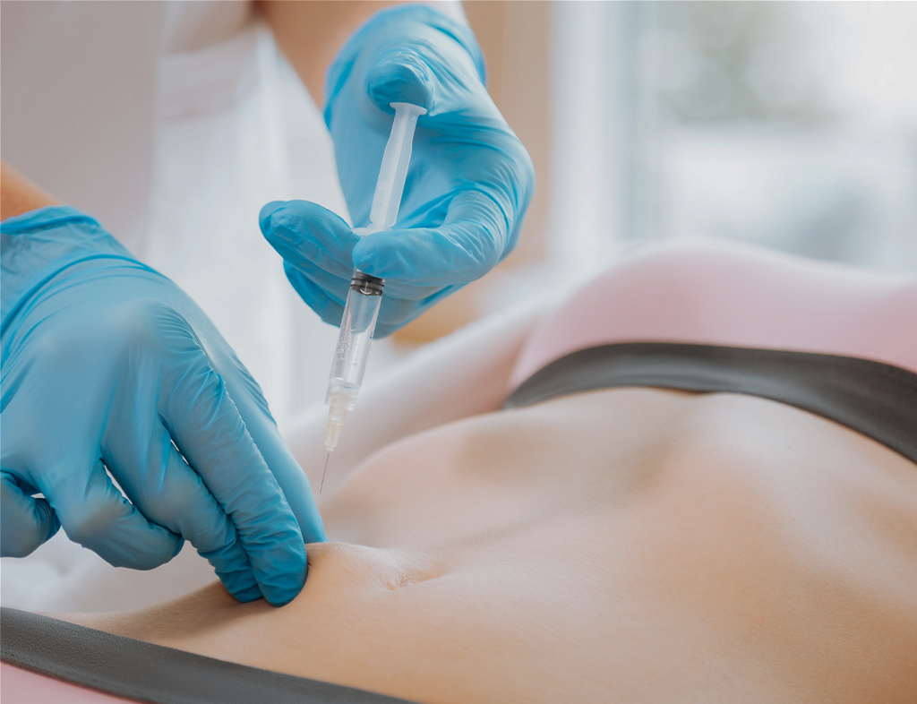 Therapist performing Mesotherapy treatment on client's abdomen for fat reduction and skin rejuvenation.